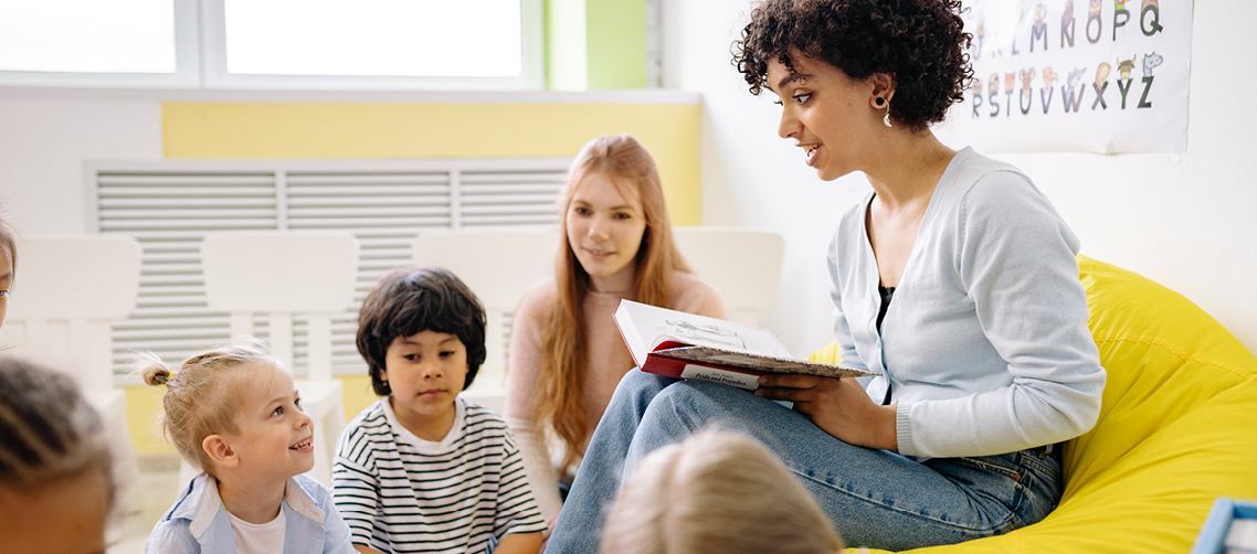 Erzieherin liest Kindern ein Buch vor